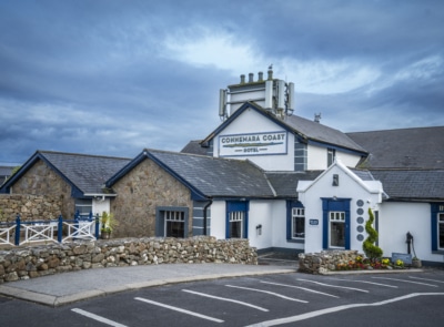 A serene coastal scene with calm waters, rocky shorelines, and vibrant sky colors during sunset or sunrise, creating a tranquil and picturesque landscape.