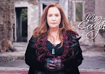 A serene coastal landscape with calm waters, rocky shoreline, and distant hills under a pastel-colored sky, featuring soft hues of pink and orange at sunset.