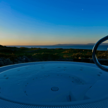 Relaxing hot tub with ocean sunset views at scenic coastal hotel.