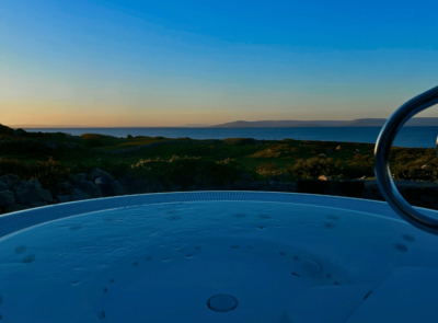 Relaxing hot tub with ocean sunset views at scenic coastal hotel.