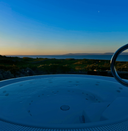 Relaxing hot tub with ocean sunset views at scenic coastal hotel.