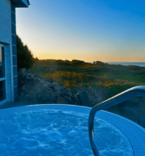 Enjoy serene coastal sunset views from the hotel's outdoor hot tub, offering relaxation and natural beauty.