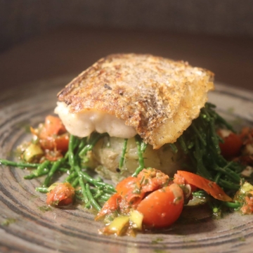 Grilled Atlantic Hake with lemon infused potato cake, sea greens and salsa Verde