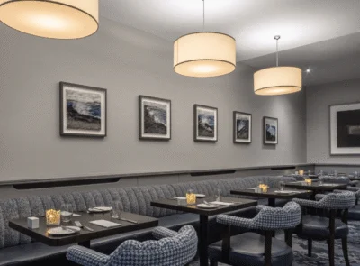 Elegant hotel dining area with cosy seating, ambient lighting, and modern artwork, perfect for a relaxing meal.