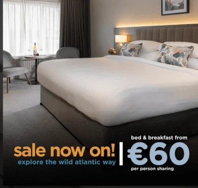 Image of a promotional sign displaying "Sales now on" with a colorful geometric background, possibly related to a sale or special offer at Connemara Coast Hotel.